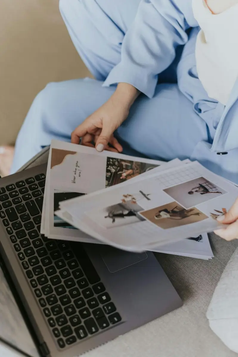 Person reviewing brand lookbooks and research materials representing the Euspree brand curation process