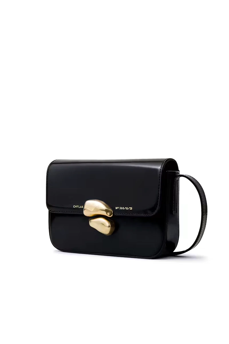 Compact glossy black CHYLAK flap bag with sculptural gold seal