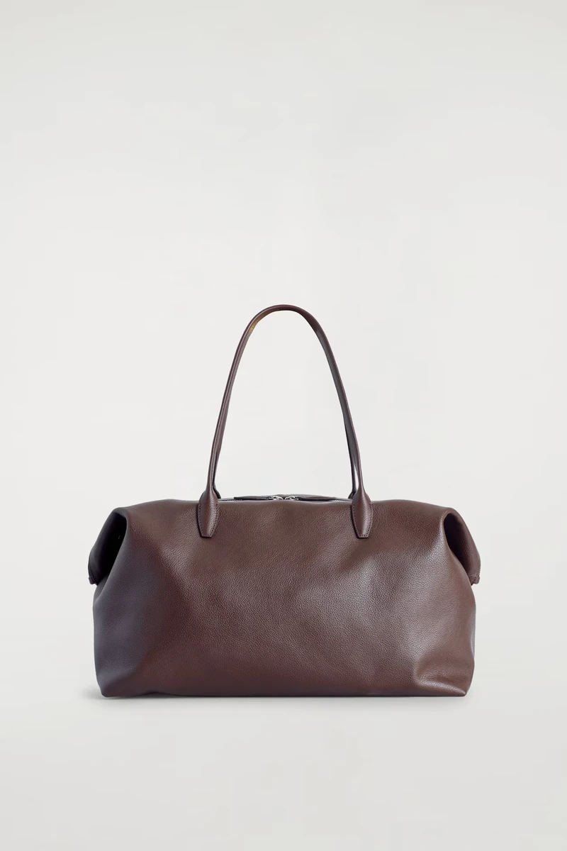 Brown leather COS Frieze bowling bag against its original studio background